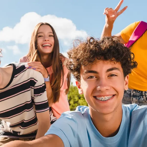 Vier fröhliche Jugendliche machen gemeinsam ein Selfie im Freien, passend zum Girls' Day und Boys' Day.
